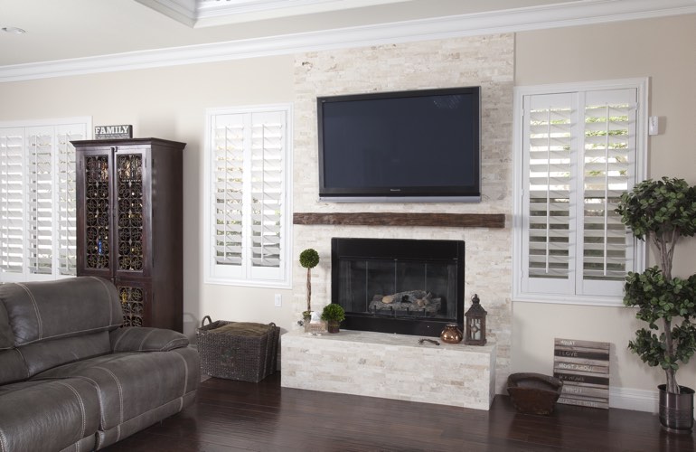 White plantation shutters in a Las Vegas living room with plank hardwood floors.